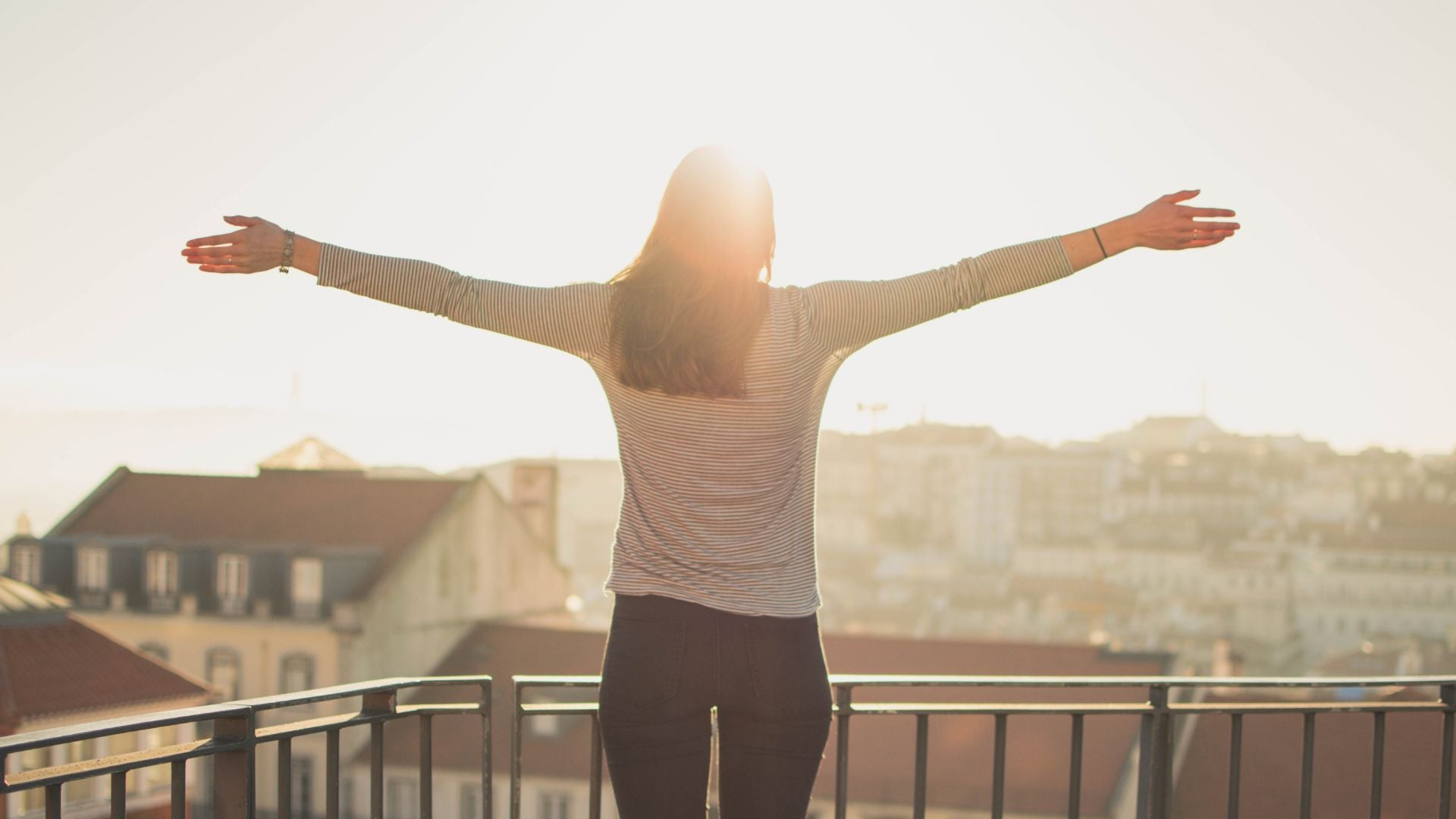 Une femme au soleil sur son balcon